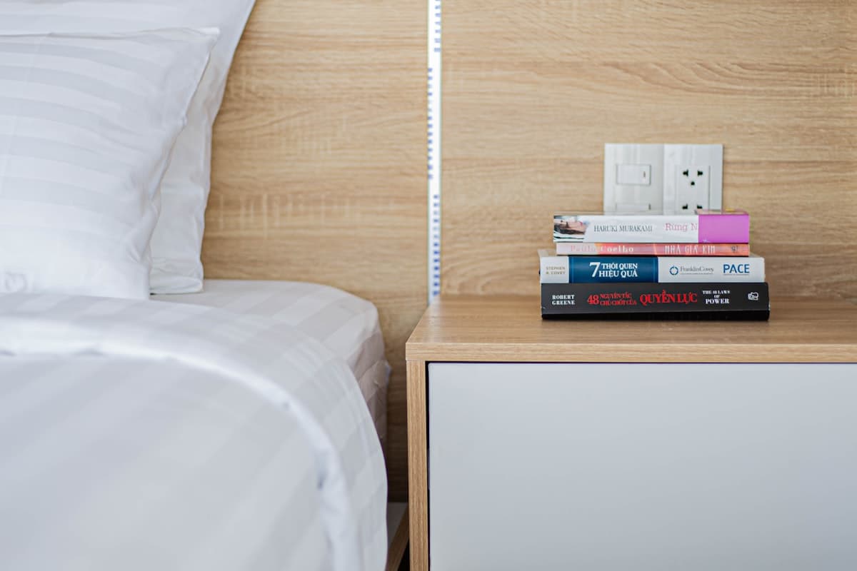 Cluttered bedroom with books on the bed before AI refresh